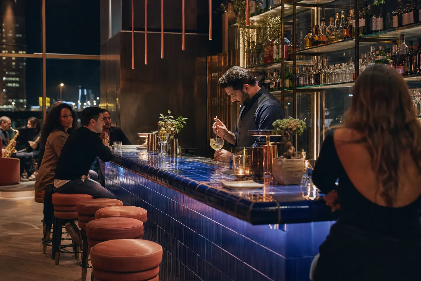 Stroombar met een lange kobaltblauwe tegelbar en een bartender aan het werk