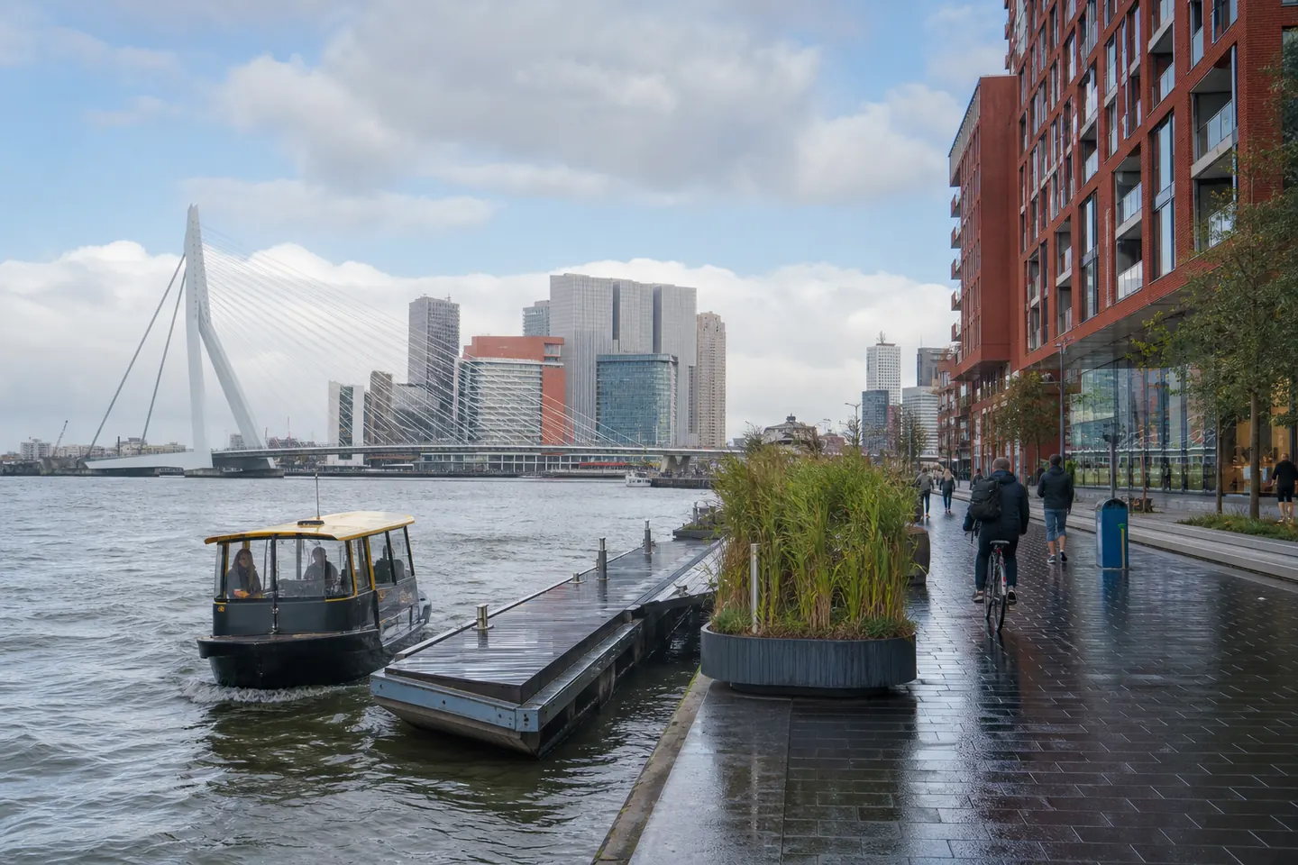 Rotterdamse Maaskade na de regen met een watertaxi, fietsers en de Erasmusbrug